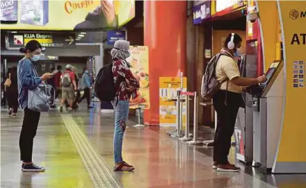  ?? PIC BY GENES VIOZEE GULITAH ?? People wearing face masks and practising physical distancing in Kuala Lumpur yesterday.