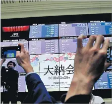  ?? Picture: REUTERS/KIM KYUNG-HOON ?? Attendees take pictures of a stock quotation board after a ceremony marking the end of trading in 2018 at the Tokyo Stock Exchange (TSE) in Tokyo, Japan.