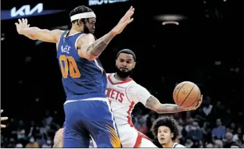  ?? ROSS D. FRANKLIN/AP ?? HOUSTON ROCKETS GUARD D.J. AUGUSTIN (front right) passes the ball to a teammate as Phoenix Suns center JaVale McGee (00) defends during the first half of a game Thursday in Phoenix.