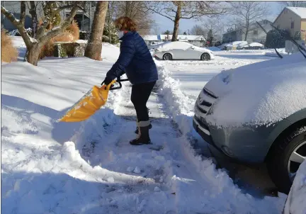  ?? RACHEL RAVINA - MEDIANEWS GROUP ?? Lansdale resident Kellé McClain shovels snow on the sidewalk by her car Thursday morning following a snow storm that impacted much of Montgomery County.