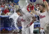  ?? LAURENCE KESTERSON — THE ASSOCIATED PRESS ?? Philadelph­ia Phillies’ Rhys Hoskins, left, is doused after hitting an RBI-double during the ninth inning for a walk-off win over the Miami Marlins on Monday.