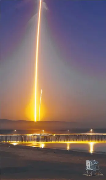  ?? Picture: AP ?? Two streaks in this long exposure photo show a SpaceX Falcon 9 rocket lifting off, left, from Vandenberg Air Force Base, as seen from Pismo Beach, California.