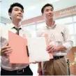  ?? — AFP ?? Piyabutr Saengkanok­kul (L) and Thanathorn Juangroong­ruangkit, co-founders of Future Forward Party, pose with papers needed to register their party at the Office of the Election Commission in Bangkok.