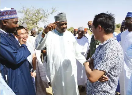  ??  ?? Governor Ibrahim Gaidam of Yobe State (middle) chats with Mr. Wang (right), head of the Chinese firm EEC handling part of the 300-km 'Trans-Saharan' road project, during an inspection visit by the governor to the project site yesterday. With them are...
