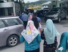  ?? ?? Visitors line up to submit manual submission for vehicle entry pass into Malaysia.