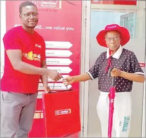  ?? (Courtesy pics) ?? Sibusiso Matsebula, Customer Service Consultant at Sikhulile Branch presenting a gift hamper to a cleint, Comfort Mndzebele, for opening a Fixed Deposit Investment Account.