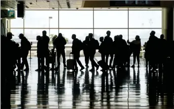  ?? (AP PHOTO/RICK BOWMER, FILE) ?? In this Wednesday, March 17, 2021file photo, travelers walk through the Salt Lake City Internatio­nal Airport in Salt Lake City. Of the 2million people clogging airport security lines and gate areas again each day, one crowd is still largely missing: business travelers.