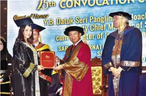  ?? ?? Well done: Gunsalam (centre) presenting a scroll to a graduate at ati College’s 25th convocatio­n ceremony in Kota Kinabalu.