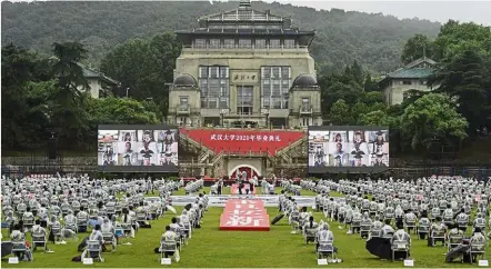  ?? — China Daily/ANN ?? New times, new rules: Graduates of Wuhan university in Wuhan practising physical distancing at their graduation ceremony.