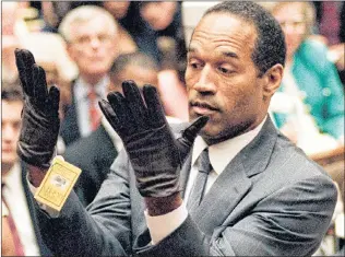  ?? AP PHOTO ?? O.J. Simpson holds up his hands before the jury after putting on a new pair of gloves similar to the infamous bloody gloves during his double-murder trial in Los Angeles on June 21, 1995.