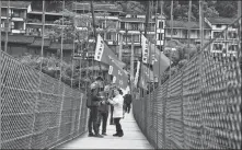  ?? YANG WENBIN / XINHUA ?? Tourists stand on a bridge in Chishui, Guizhou province, which is rich in red tourism resources.