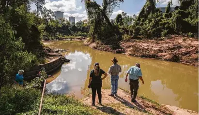  ?? Mark Mulligan / Staff photograph­er ?? Conservati­onists inspect a point on Buffalo Bayou nearWest Loop 610 where erosion is pushing sediment downstream.