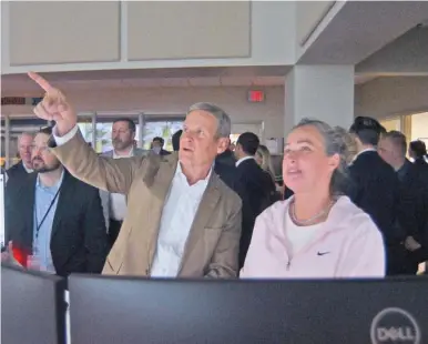  ?? STAFF PHOTOS BY MATT HAMILTON ?? Gov. Bill Lee points at a wall of monitors displaying video feeds from highway cameras Monday while talking to traffic monitoring center supervisor Holly Crittenden at a Tennessee Department of Transporta­tion location in Chattanoog­a.