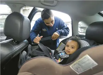  ?? RICH PEDRONCELL­I/AP ?? Shannon Henderson buckles her son, Justin, 1, into his car seat for the ride to his father’s house before she goes to her job as a part-time customer service representa­tive at Wal-Mart in Sacramento, California. Henderson is one of an estimated 40 million American workers for who calling in sick is a luxury. If they don’t work, they don’t get paid.