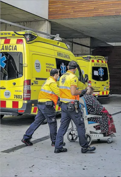  ?? Treballado­rs d'una ambulància acompanyen una dona cap a l'Hospital de Bellvitge. ?? JORDI OTIX