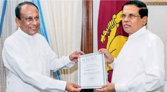  ??  ?? President Sirisena in his capacity as party leader, handing over the letter of appointmen­t to Minister LakshmanYa­pa Abeywarden­a as the new district organiser for Matara