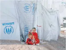  ??  ?? Displaced children sit outside a tent at Hassan Sham Camp, east of Mosul.