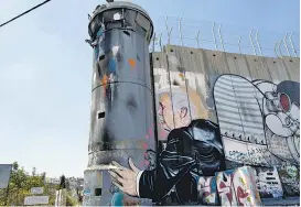  ??  ?? Dos grafitis de Trump apareciero­n en el muro entre israelíes y palestinos.