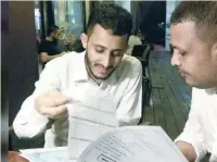  ?? — Reuters ?? Yemeni Rafek Ahmed Mohammed al Sanani (R), and Abdel Rahman Zaid, look through documents as they speak in Serdang, on the outskirts of Kuala Lumpur, Malaysia.