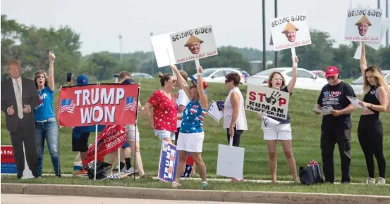  ?? ASHLEE REZIN/SUN-TIMES ?? Supporters of former President Donald Trump protest in July 2021 outside McHenry County College in Crystal Lake before a speech by President Joe Biden.