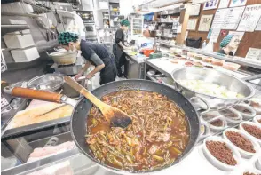  ?? ?? Staff members preparing ingredient­s ahead of opening for the day’s trade at the restaurant Onigiri Bongo, a shop specialisi­ng in rice balls known as ‘onigiri’, in the Otsuka area of Tokyo.