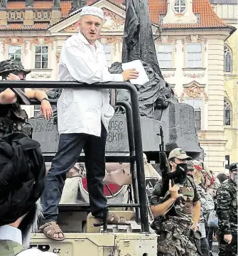  ?? Přívrženci Martina Konvičky (v bílém) sehráli v neděli na Staroměsts­kém náměstí invazi islamistů do Česka. Podle primátorky Andrey Krnáčové měl magistrát akci, jež vyděsila desítky turistů, zakázat. FOTO ČTK ?? Děsivé představen­í.