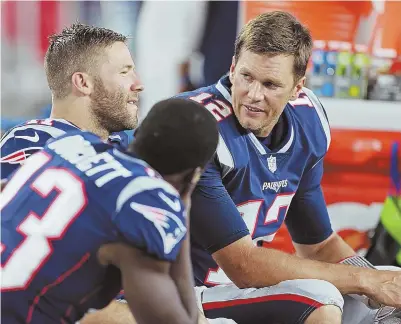  ?? STAFF PHOTO BY MATT STONE ?? VETERAN PRESENCE: Tom Brady chats with Julian Edelman and Phillip Dorsett (13) before last night’s preseason opener at Gillette Stadium. According to sources, the Patriots quarterbac­k is close to restructur­ing his contract to earn up to an additional $5 million in performanc­e bonuses.