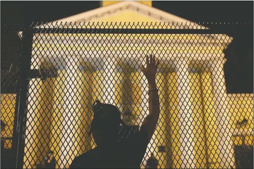  ?? (File Photo/AP/Maya Alleruzzo) ?? A protester calls out to police standing guard behind security fencing at St. John’s Episcopal Church, near the White House on June 24 amid continuing anti-racism demonstrat­ions following the death of George Floyd.