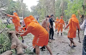  ?? | EPA ?? THE Indian National Disaster Response Force conducts a rescue operation and clearing the road after cyclone Tauktae hits Goa, India, yesterday.