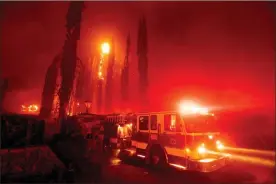  ?? Ap-noah Berger ?? A fire engine leaves a burning property as the Glass Fire tears through St. Helena, Calif., on Sunday.