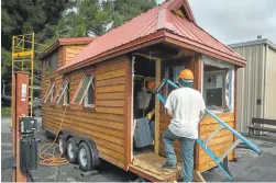  ??  ?? Students work on the “tiny house” at Blue Ridge School in Morgan Hill. The students have been building the miniature house for about a year to learn constructi­on skills.