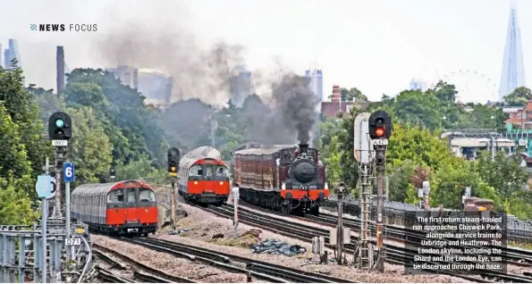  ??  ?? The first return steam-hauled run approaches Chiswick Park, alongside service trains to Uxbridge and Heathrow. The London skyline, including the Shard and the London Eye, can be discerned through the haze.