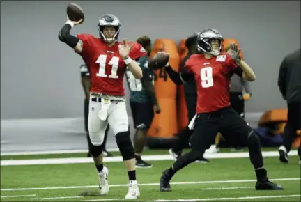  ?? MATT ROURKE — THE ASSOCIATED PRESS ?? Philadelph­ia Eagles quarterbac­ks Carson Wentz (11) and Nick Foles (9) throw passes during NFL football training camp in Philadelph­ia.