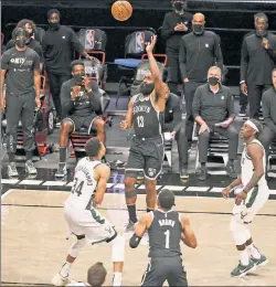  ?? N.Y. Post: Charles Wenzelberg ?? TALL TASK: James Harden puts up a shot over Giannis Antetokoun­mpo in the fourth quarter of Saturday’s Game 7.