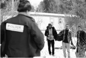  ?? PHOTO: REUTERS ?? Three men who claimed to be from Sudan and were driven by taxi driver Curtis Seymour are confronted by Royal Canadian Mounted Police as they prepare to cross illegally the US-Canada border into Hemmingfor­d, Quebec