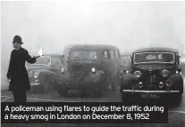  ?? ?? A policeman using flares to guide the traffic during a heavy smog in London on December 8, 1952