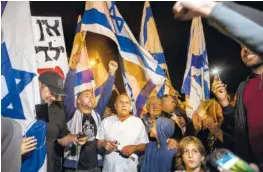  ?? AP PHOTO/TSAFRIR ABAYOV ?? Israeli protesters hold flags during a demonstrat­ion against the cease-fire between Israel and Gaza’s Hamas in the southern Israeli city of Ashkelon on Wednesday.