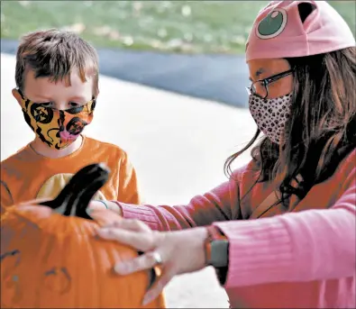  ?? BILL JONES/DAILY SOUTHTOWN PHOTOS ?? Logan and Emily Bettcher, of Oak Lawn, work together on a jack-o’-lantern during Oak Lawn Park District’s event.