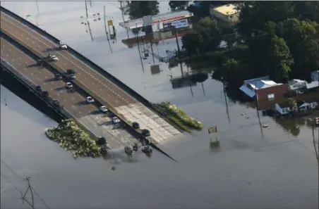  ?? GERALD HERBERT — THE ASSOCIATED PRESS ?? People launch boats from an overpass into floodwater­s in the aftermath of Tropical Storm Harvey in Kountze, Texas, Thursday.