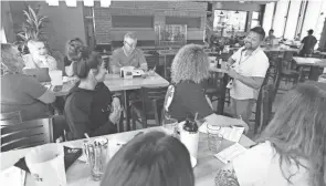  ?? DORAL CHENOWETH/COLUMBUS DISPATCH ?? Chris Venci leads a wine and champagne tasting for employees at Moran's, a new bar opening soon at 415 N. Front St. in the Arena District.