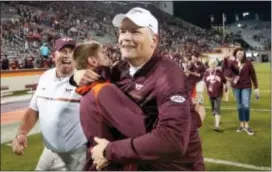  ?? STEVE HELBER — THE ASSOCIATED PRESS ?? Virginia Tech head coach Justin Fuente hugs a fan after his team defeated Miami 37-16 at Lane stadium in Blacksburg, Va., Thursday.