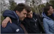  ?? EMILIO MORENATTI — THE ASSOCIATED PRESS ?? Yura Nechyporen­ko, 15, hugs his uncle Andriy Nechyporen­ko next to the grave of his father, Ruslan Nechyporen­ko, at the cemetery in Bucha, on the outskirts of Kyiv, Ukraine, on Monday.