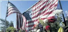  ?? RICH PEDRONCELL­I/THE ASSOCIATED PRESS ?? Flags and flowers make up a memorial on the backyard fence of a Las Vegas shooting victim, on Wednesday, in Cameron Park, Calif.