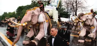  ??  ?? Mahouts lead 11 white elephants to kneel in front of the Grand Palace in honor of Thailand’s King Bhumibol Adulyadej in Bangkok, Thailand, Tuesday. — AP photos