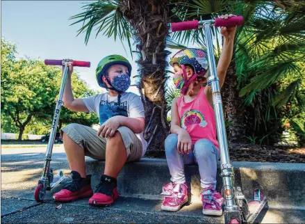  ?? ALIE SKOWRONSKI / SACRAMENTO BEE / TNS ?? Mason Gottis, 9, and his sister Violette, 7, take a break from riding their scooters in East Sacramento, Calif., last month. Mason has chronic health conditions, including Type 1 diabetes and severe asthma, which elevate his risk from COVID-19.