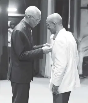  ?? (Photo by Terrence Thompson) ?? Stabroek Business Editor Arnon Adams receives the Golden Arrow of Achievemen­t from President David Granger.