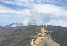  ?? AP PHoTo ?? This photo provided by KEYT-TV shows smoke looming above Broadcast Peak behind a fire break along a ridge line east of Cachuma Lake in Santa Barbara County, Calif., Sunday. Wildfires barreled across the baking landscape of the western U.S. and Canada,...