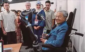  ?? BERNAMA PIC ?? Prime Minister Tun Dr Mahathir Mohamad sitting on a wheelchair that is equipped with a robotic arm at the Ageing, Learning and Technology: Enriching Lives, Connecting Communitie­s Conference 2018 event in Kuala Lumpur yesterday.