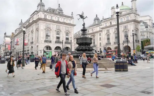  ?? Agence France-presse ?? Pedestrian­s walk past Picadilly Circus in ↑ London, UK, on Friday.