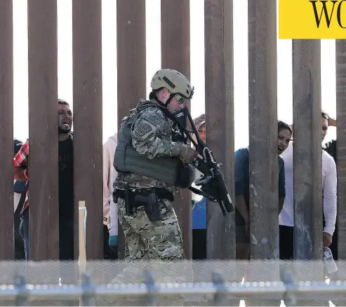  ?? GREG BULL / THE ASSOCIATED PRESS ?? A U.S. Customs and Border Protection officer walks along a barrier at the Mexico-U.S. border, in San Diego, Calif., on Sunday. Migrants attempted to penetrate several points along the border.